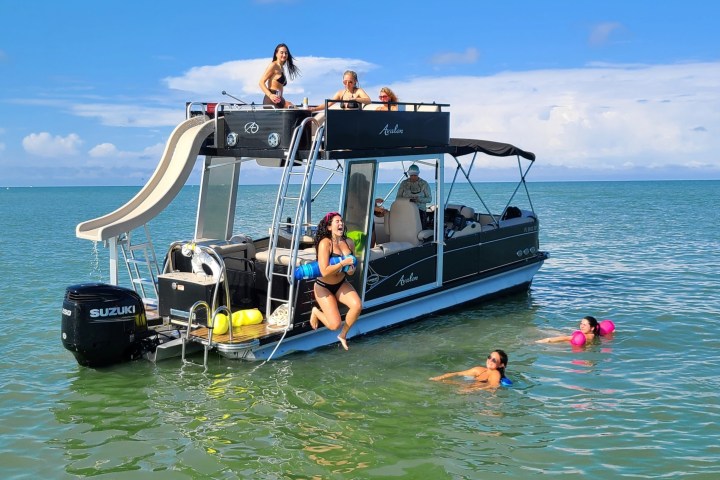 a group of people riding on the back of a boat in the water